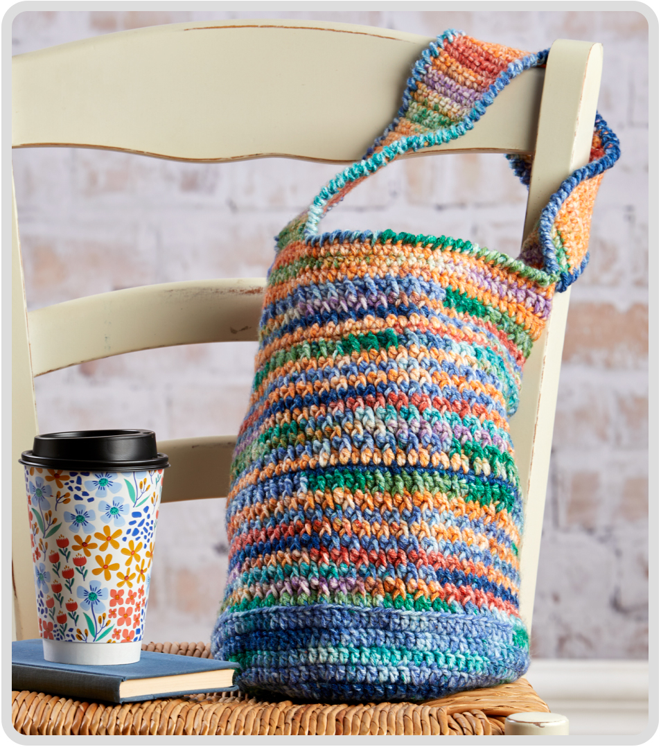 Colorful crochet Color Clash tote bag next to a coffee cup